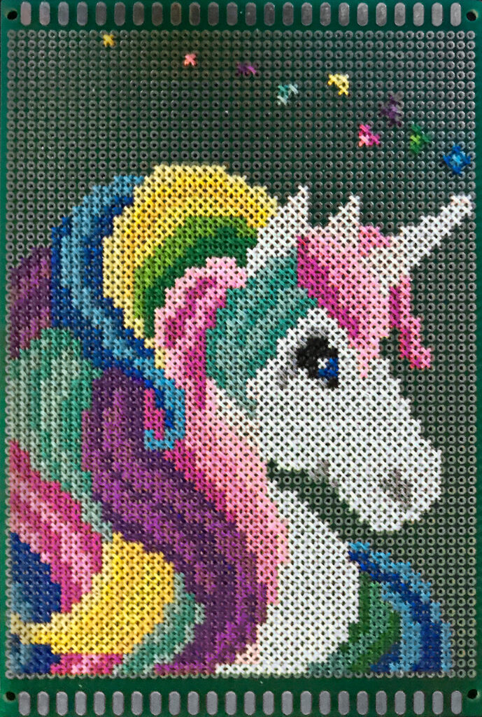 The head of a white unicorn with multicolored mane, cross-stitched on a green and silver circuit board.