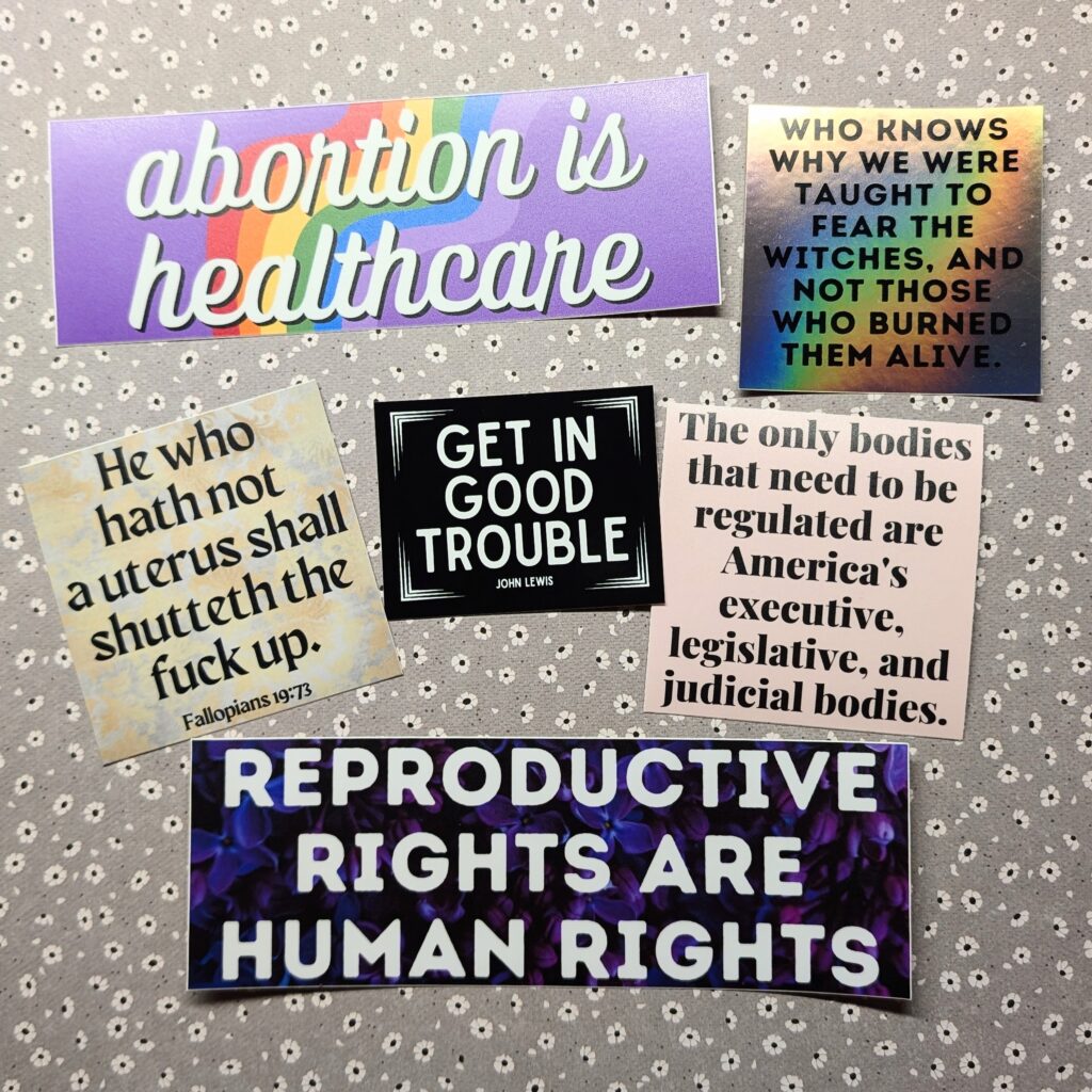 Six stickers with political and abortion-rights-related sayings.